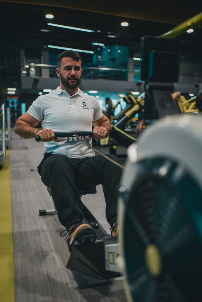 Sesión de entrenamiento en el gimnasio con un entrenador personal, enfocada en el rendimiento y el bienestar físico.